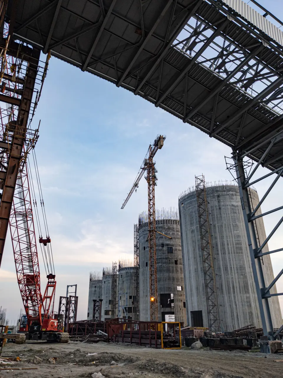 Industrial construction site in Bangladesh with cranes and silo structures